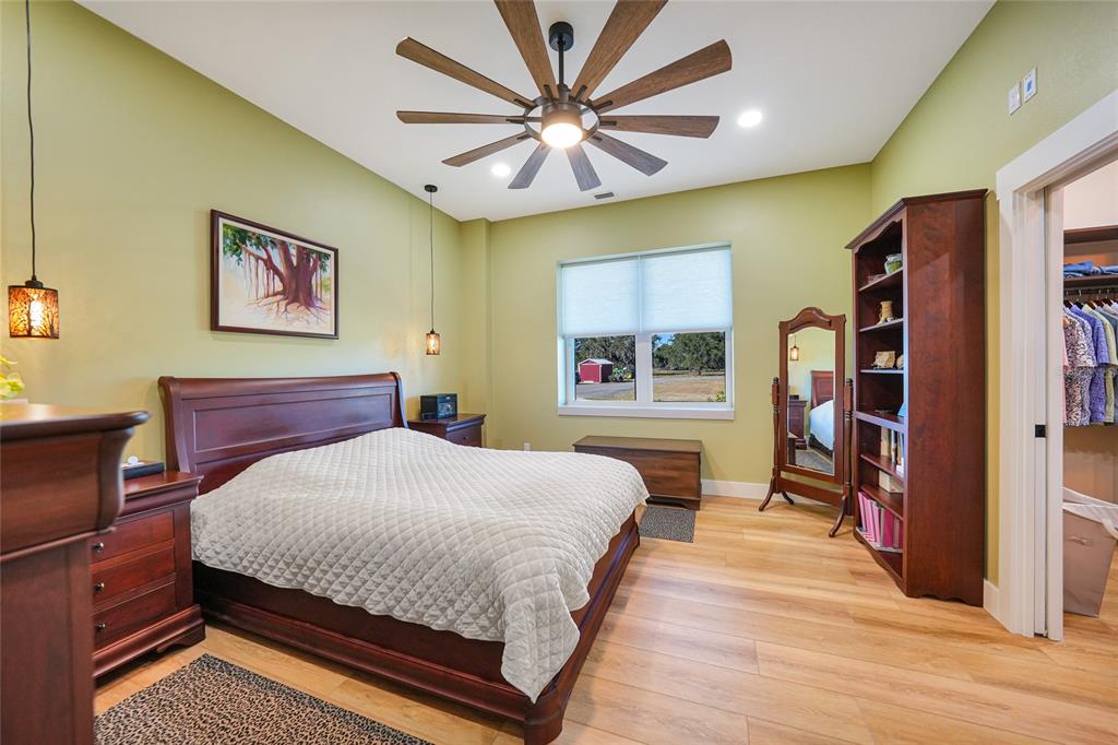 3321 Southwest Martin Lane Arcadia, FL 34266 - Photo 21 of 81 a bedroom with a bed and a bookshelf with wooden floor