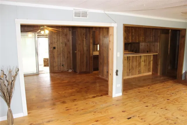 a view of hallway with wooden floor and door