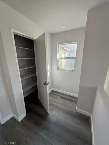 an empty room with wooden floor and window