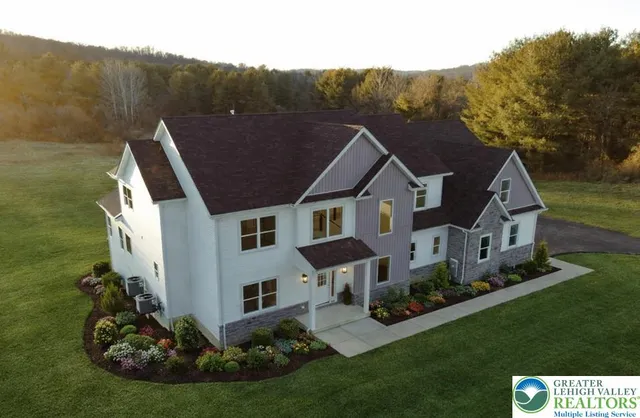 a aerial view of a house next to a big yard and large trees