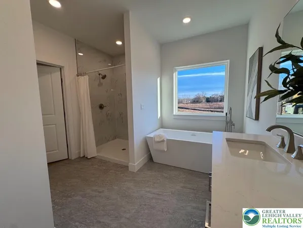 a bathroom with a tub a sink and mirror