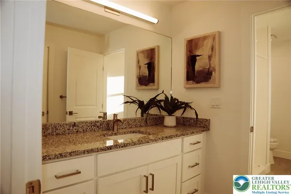 a bathroom with a granite countertop sink and a mirror