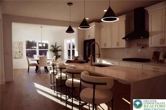 a kitchen with stainless steel appliances granite countertop a stove a sink a dining table and chairs with wooden floor