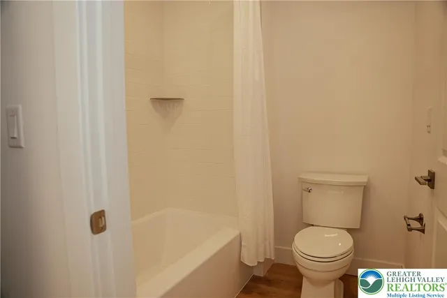 a white toilet sitting next to a bath tub