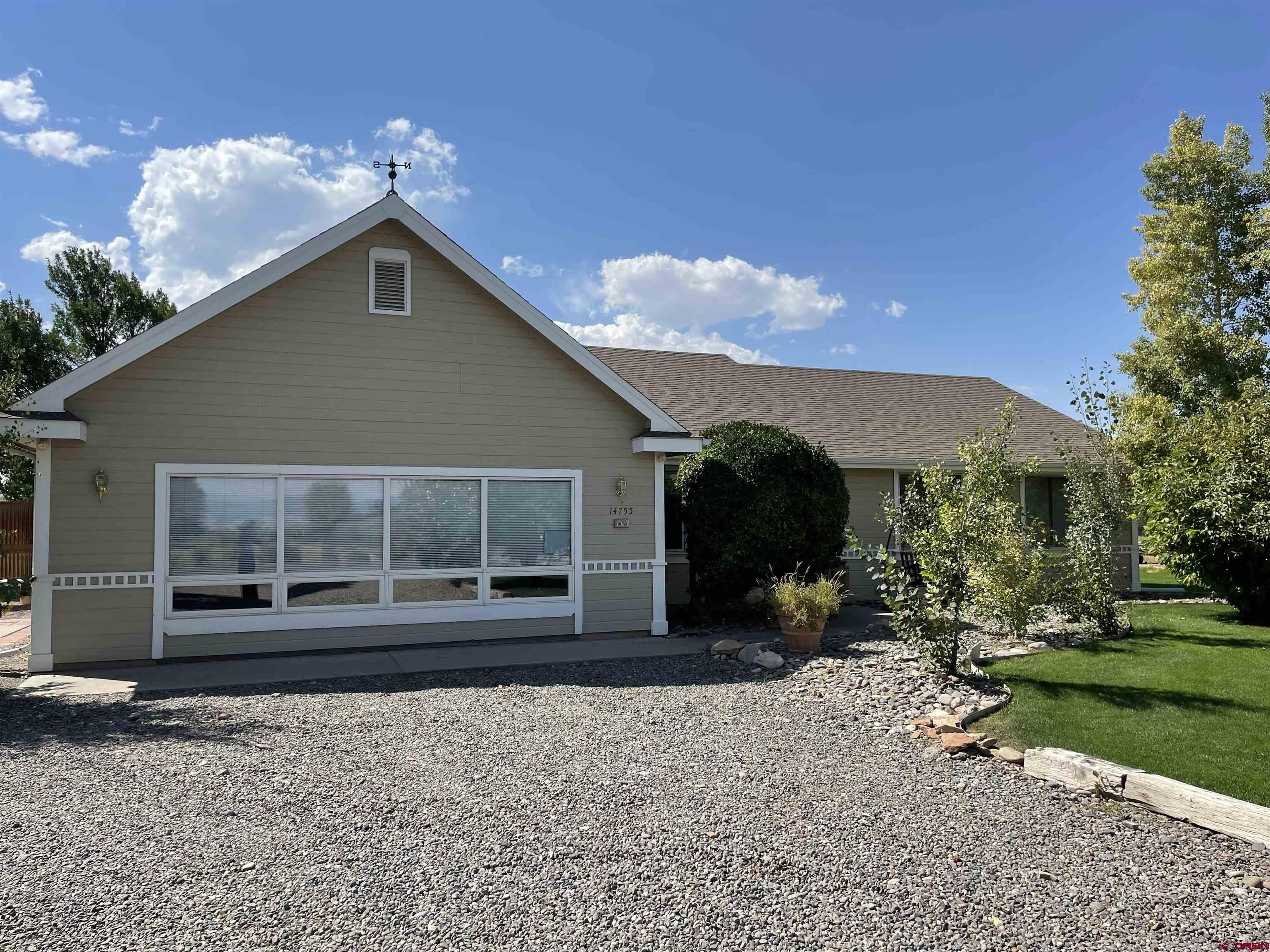 14755 6215th Road Montrose, CO 81403 - Photo 2 of 34 a front view of a house with garden