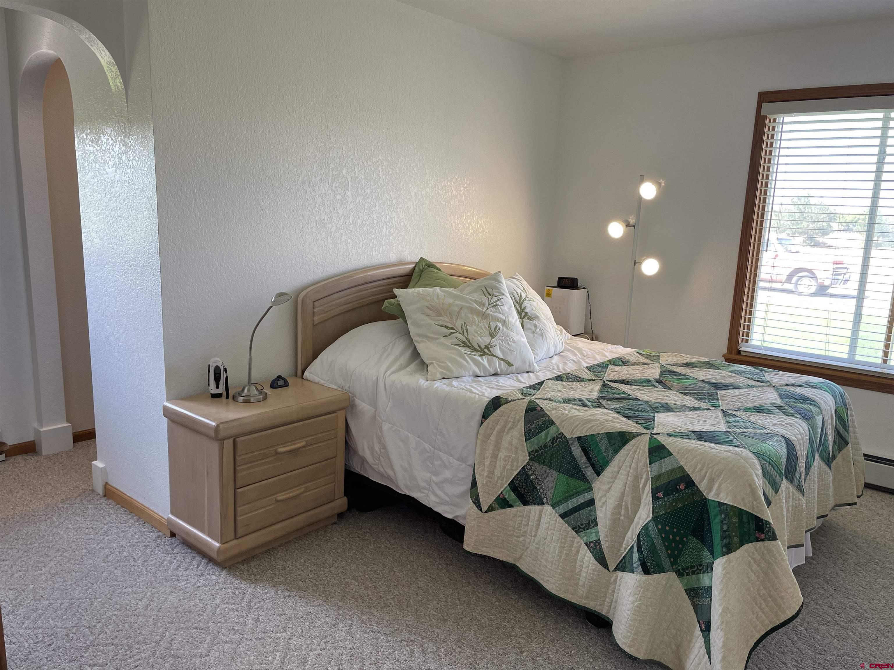 14755 6215th Road Montrose, CO 81403 - Photo 21 of 34 a bed sitting in a bedroom next to a window and a larger closet