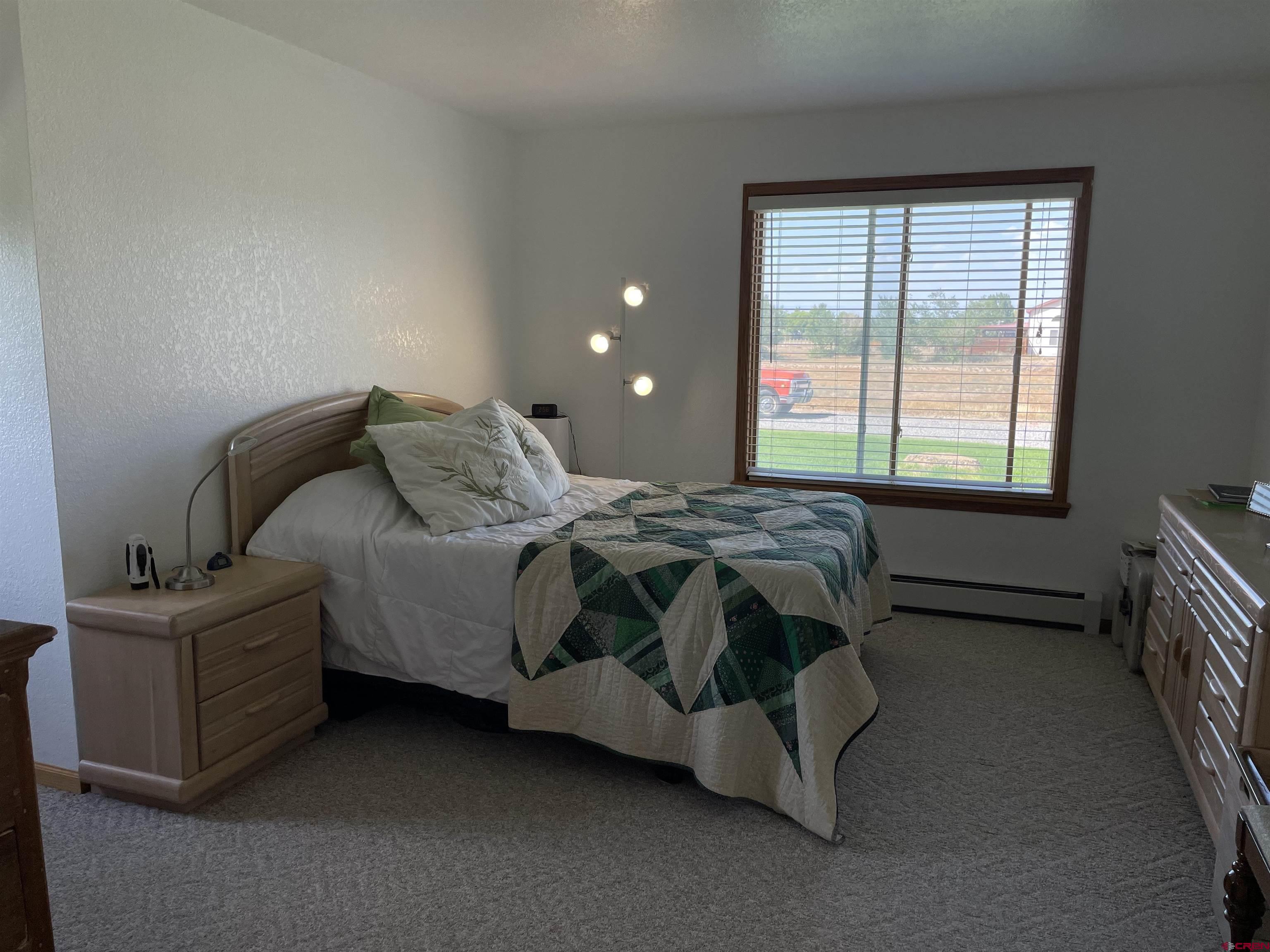14755 6215th Road Montrose, CO 81403 - Photo 22 of 34 a bed sitting in a bedroom next to a window