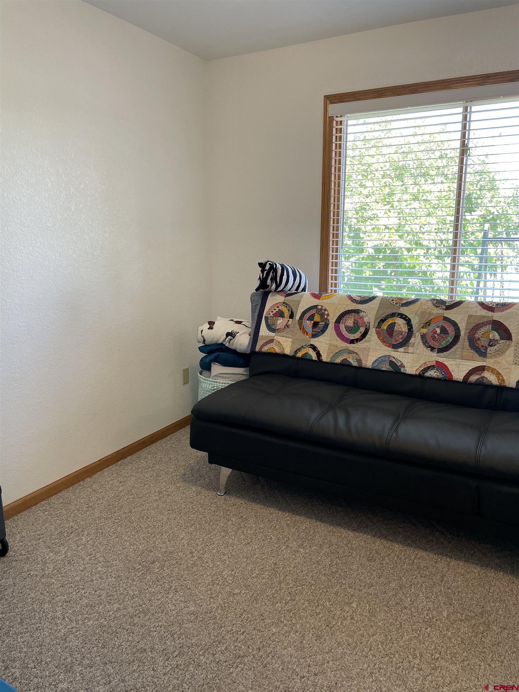 14755 6215th Road Montrose, CO 81403 - Photo 24 of 34 a bed sitting in a bedroom next to a window