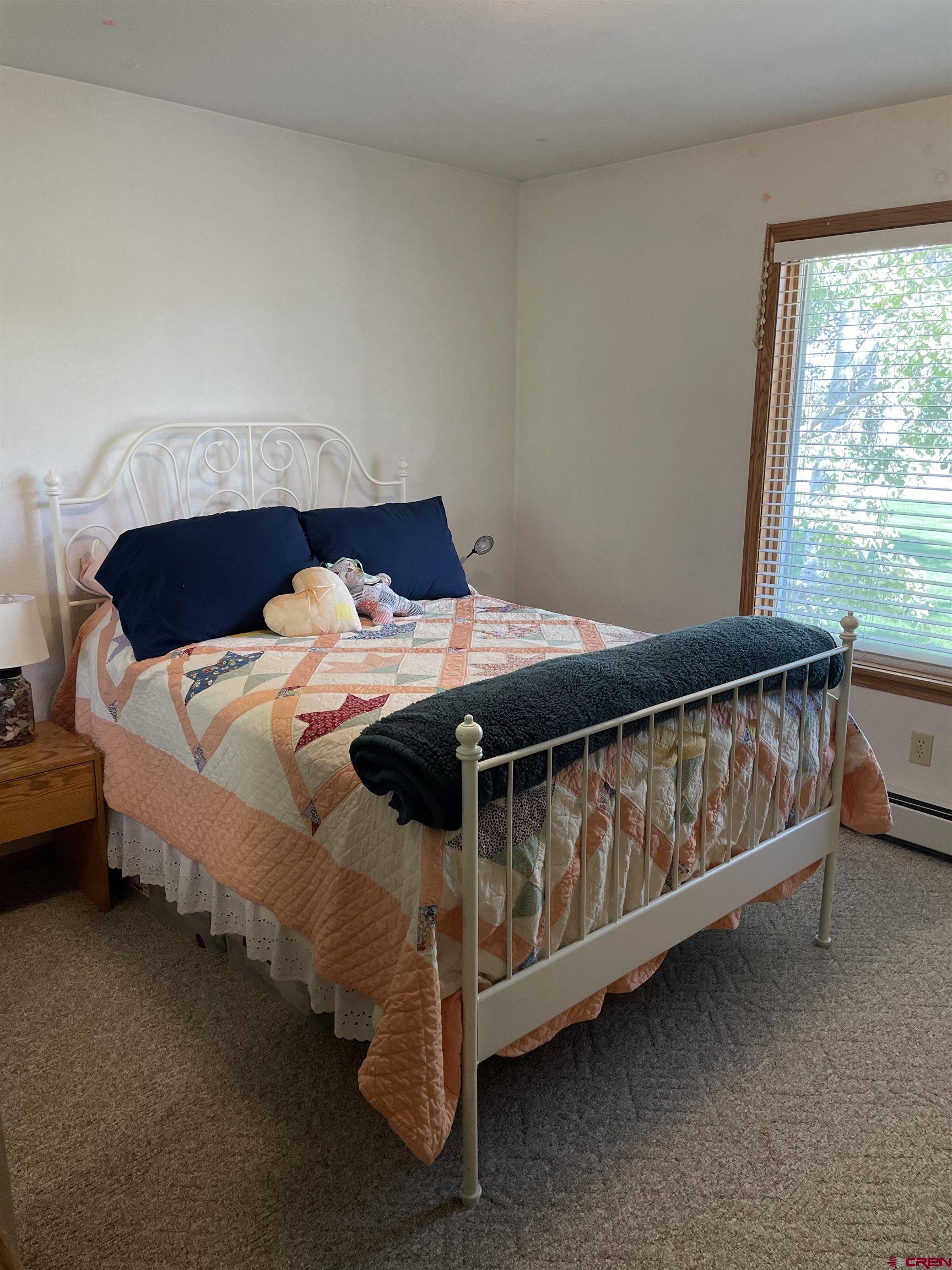 14755 6215th Road Montrose, CO 81403 - Photo 25 of 34 a bed sitting in a bedroom next to a window