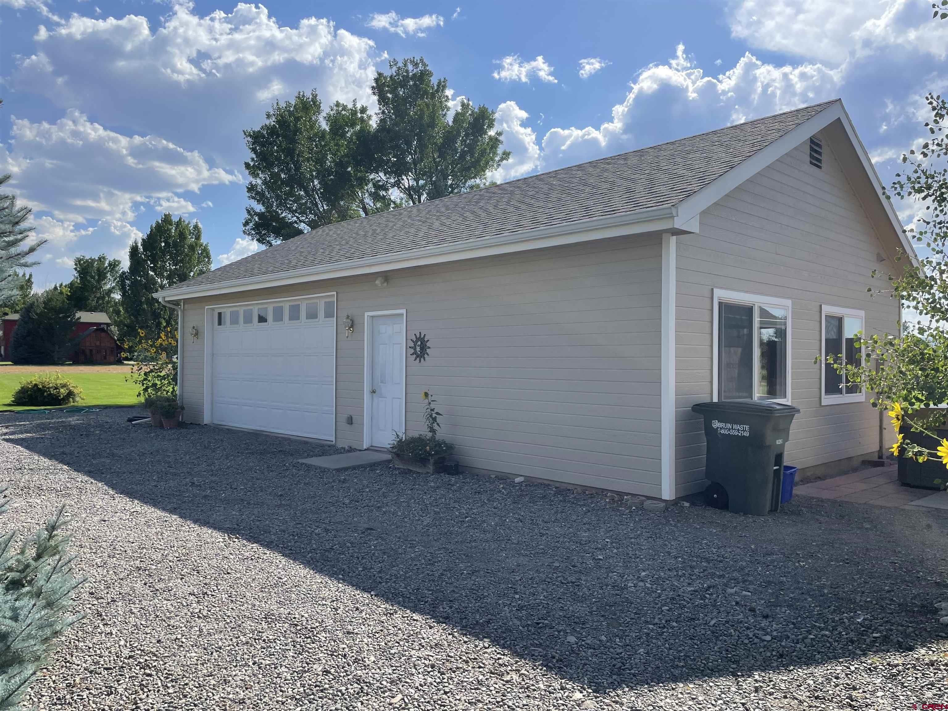 14755 6215th Road Montrose, CO 81403 - Photo 4 of 34 a view of a house with a yard and garage