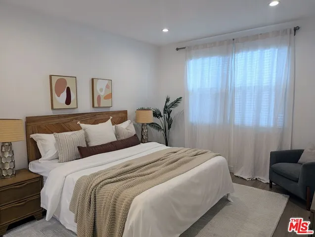 a bedroom with bed couch and window