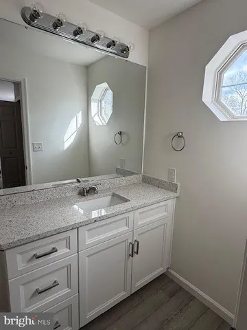 a bathroom with a granite countertop sink mirror and vanity