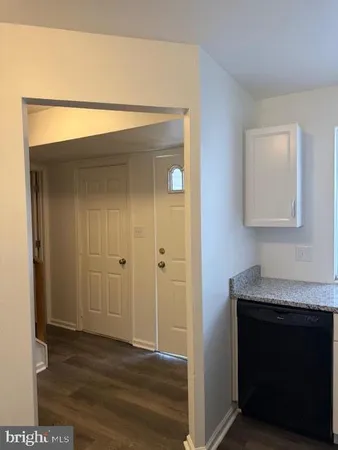 a view of hallway with wooden floor and cabinet