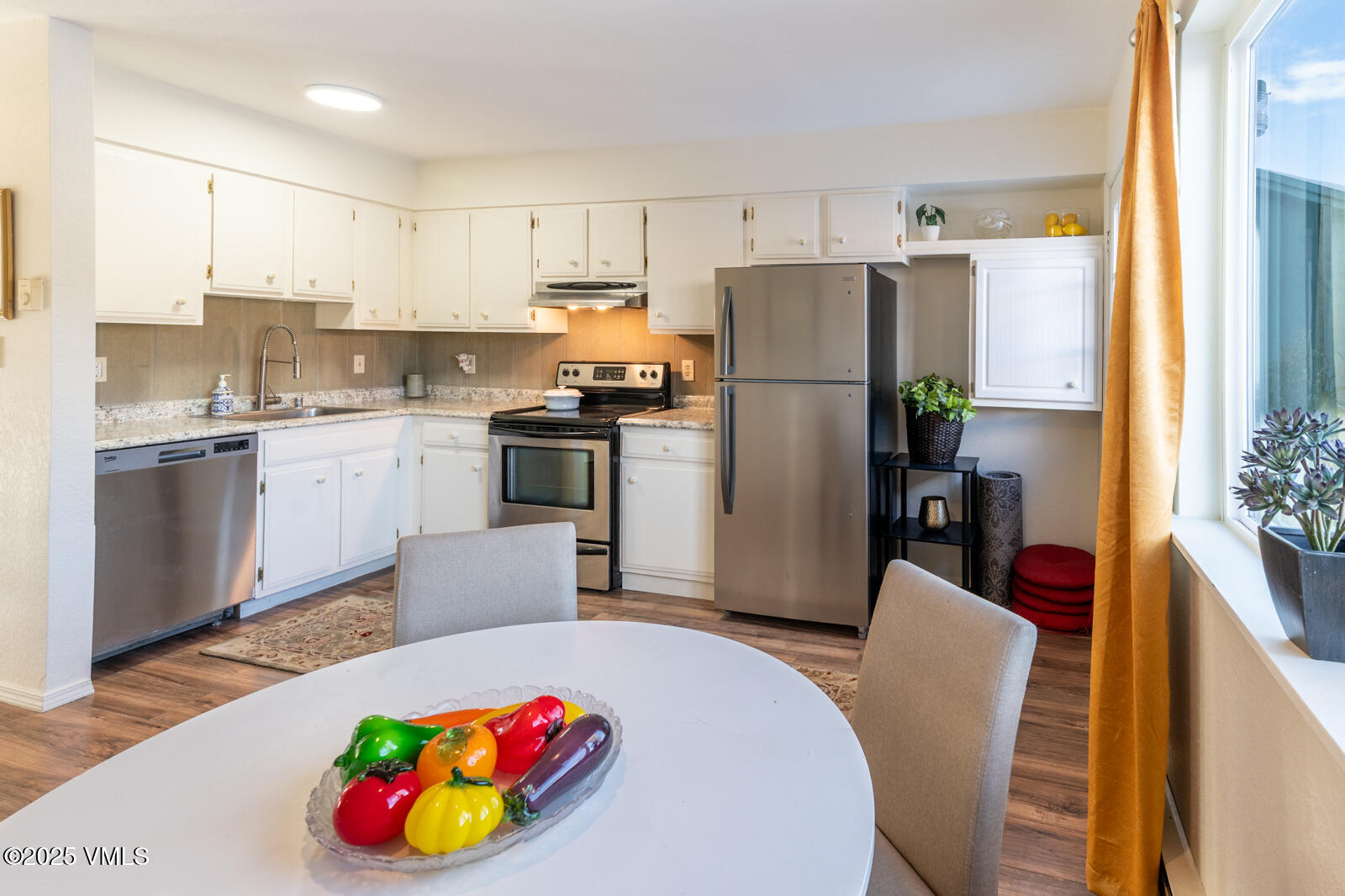 85 Chambers Avenue, Unit 10 Eagle, CO 81631 - Photo 13 of 37 a kitchen with a refrigerator a stove a sink dishwasher with a dining table and chairs