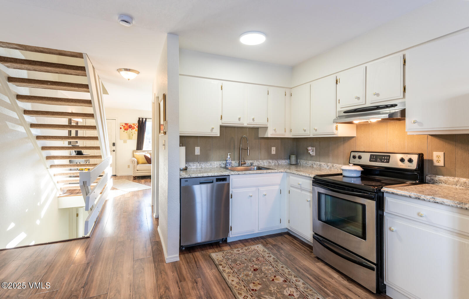85 Chambers Avenue, Unit 10 Eagle, CO 81631 - Photo 8 of 37 a kitchen with granite countertop white cabinets and white appliances
