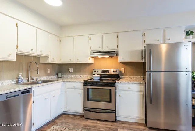 a kitchen with cabinets stainless steel appliances and a sink