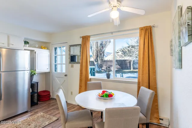 a view of a dining room with furniture large window and refrigerator