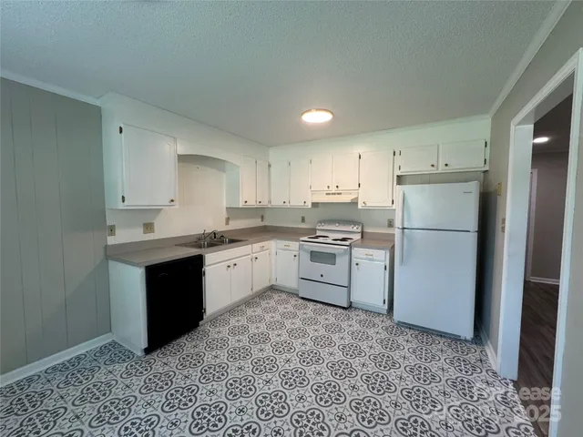 a kitchen with a sink refrigerator and cabinets