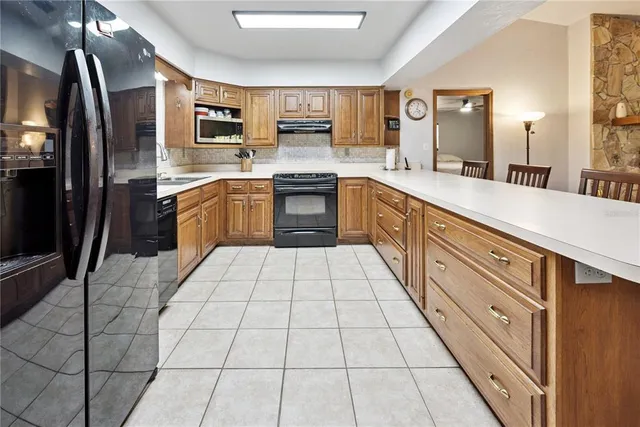 a large kitchen with a stove top oven a sink a counter space and cabinets