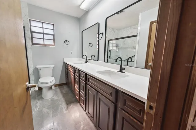 a bathroom with a sink a toilet and a mirror