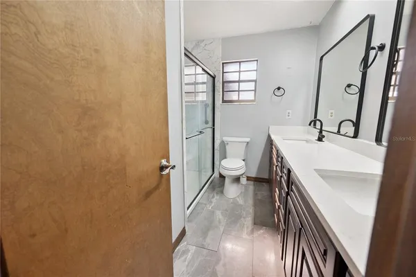 a bathroom with a sink a toilet and shower
