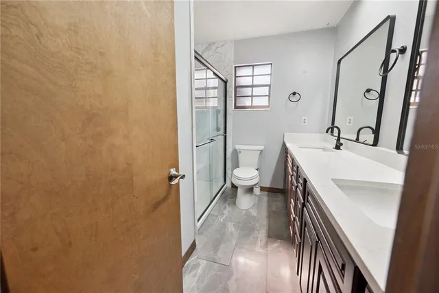 a bathroom with a sink a toilet and shower