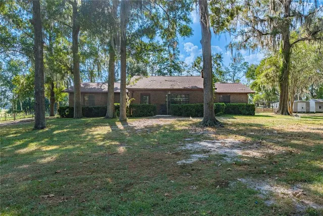 a view of a house with backyard and a tree