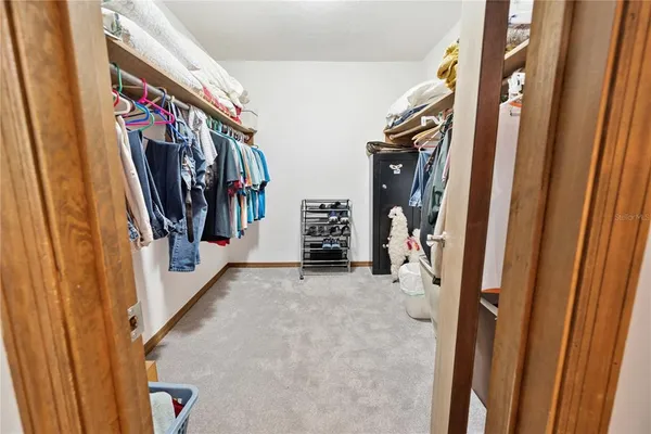 a view of walk in closet with clothes and shoes