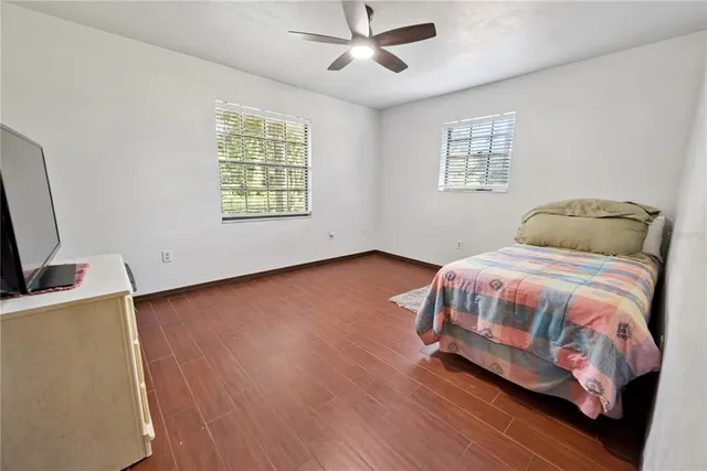 a bedroom with a bed and a flat tv screen on dresser