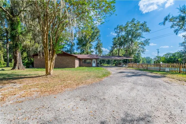 a view of a house with backyard and tree s