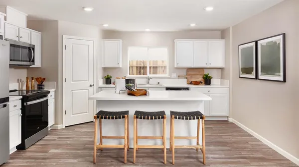 a kitchen with stainless steel appliances granite countertop a table chairs microwave and sink