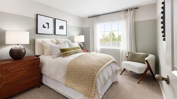 a bedroom with a bed and a chair