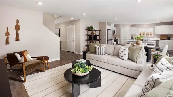 a living room with furniture and a dining table with kitchen view
