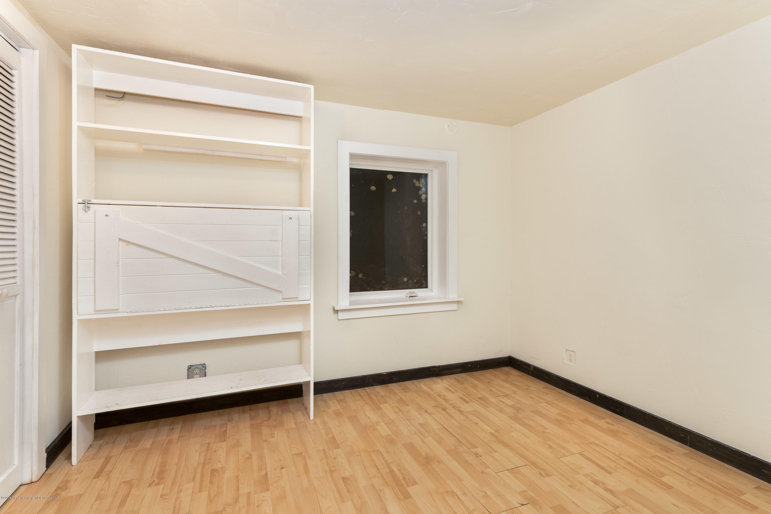 331 Holland Hills Road, Unit 6 Basalt, CO 81621 - Photo 17 of 27 a view of an empty room with wooden floor and a window