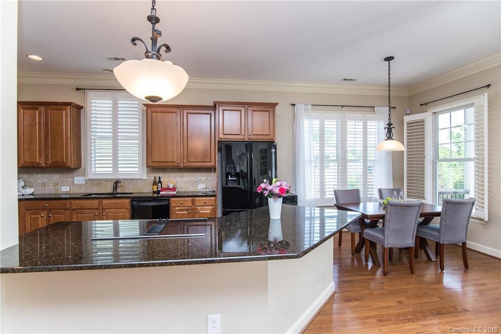 944 Gardenia Street Fort Mill, SC 29708 - Photo 17 of 35 a kitchen with granite countertop a stove a sink a dining table and chairs