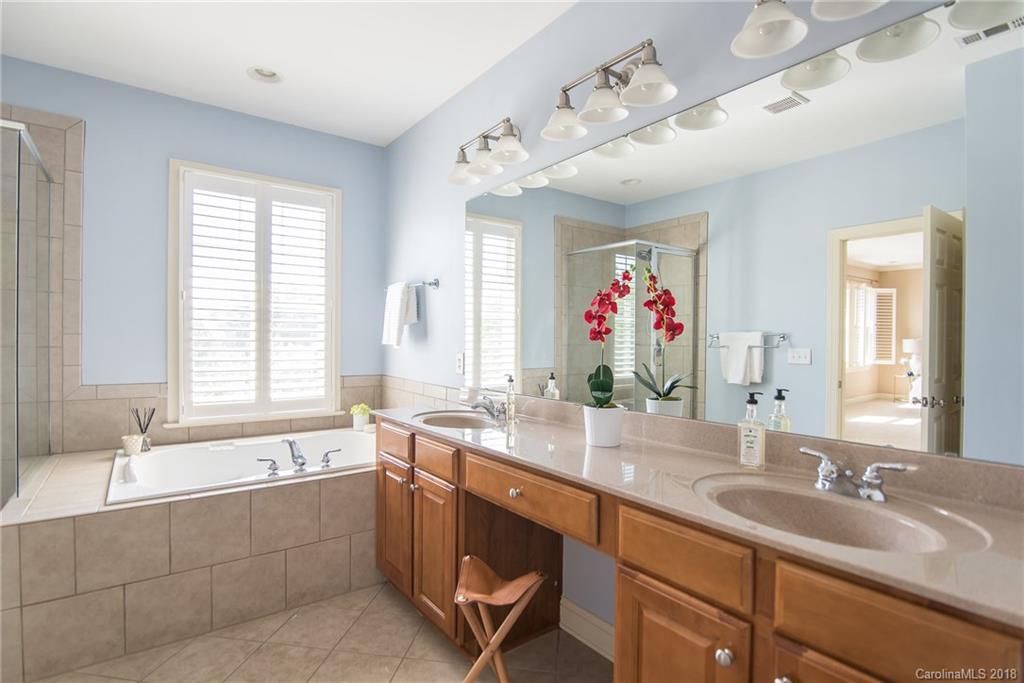 944 Gardenia Street Fort Mill, SC 29708 - Photo 33 of 35 a bathroom with a granite countertop sink mirror and a bathtub