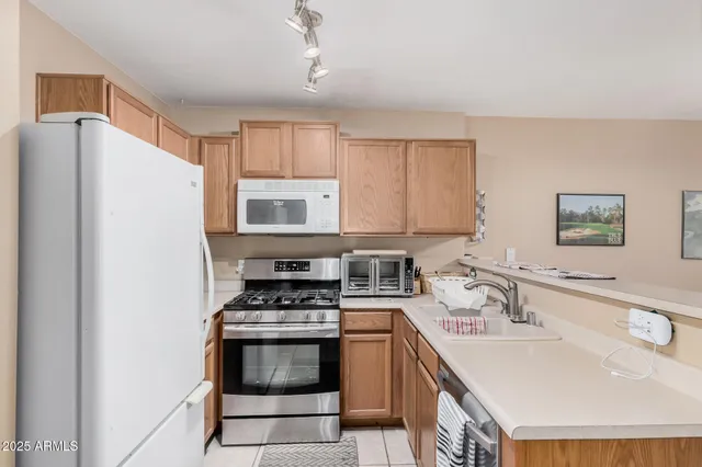a kitchen with stainless steel appliances a stove a sink a refrigerator and cabinets