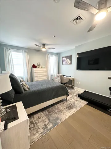 a bedroom with a bed a flat screen tv and couches