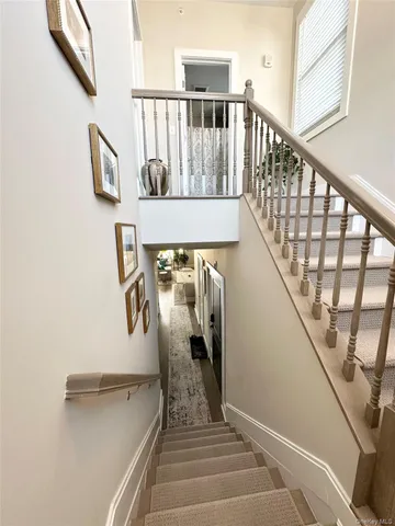 a view of staircase with railing and white walls