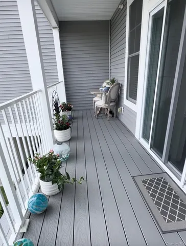 a view of a roof deck with table and chairs and wooden floor