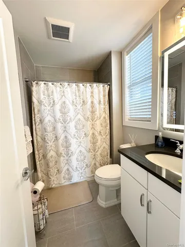 a bathroom with a granite countertop sink toilet and a shower