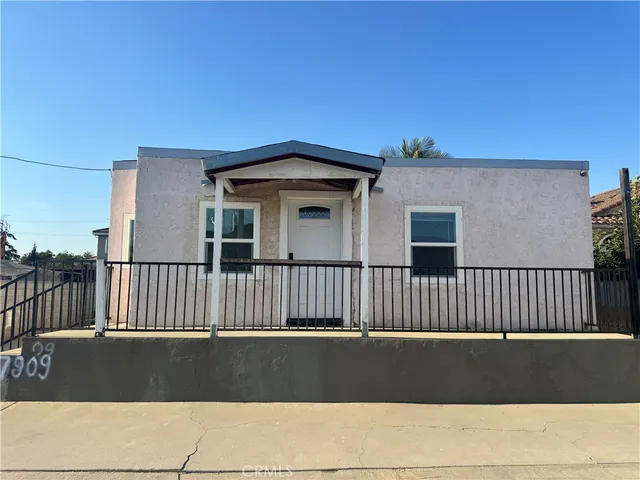a side view of a house with a wooden fence