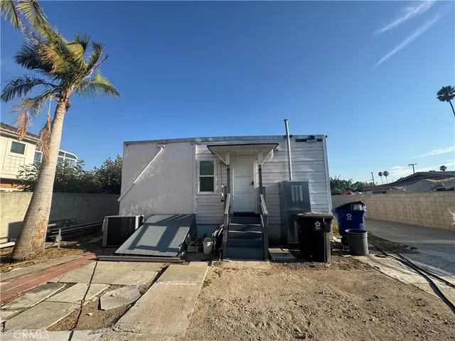 a backyard of a house with barbeque oven and outdoor seating