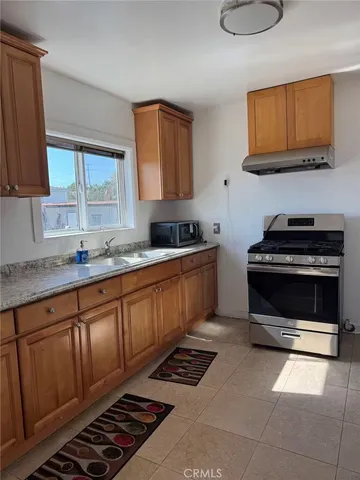 a kitchen with stainless steel appliances a stove a sink and a microwave