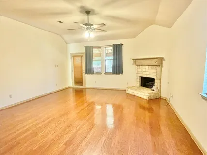 a view of an empty room with a fireplace and a window