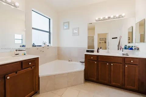 a bathroom with a tub sink and mirror