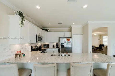 a kitchen with stainless steel appliances granite countertop a sink a stove and a refrigerator