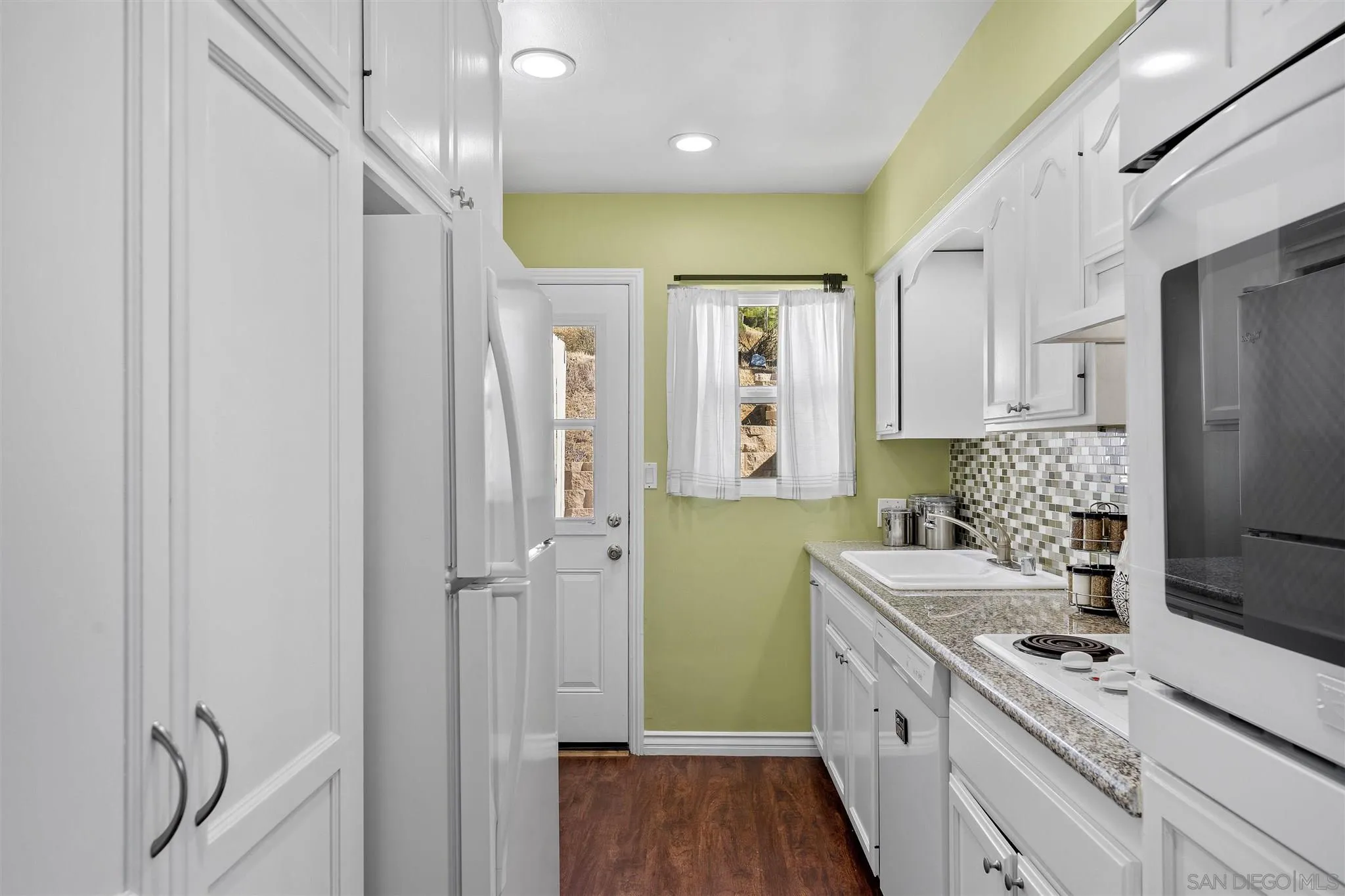 9115 Old Castle Road Valley Center, CA 92082 - Photo 10 of 30 a kitchen with a refrigerator a sink and cabinets