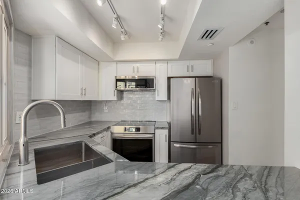 a kitchen with stainless steel appliances granite countertop a sink stove and refrigerator