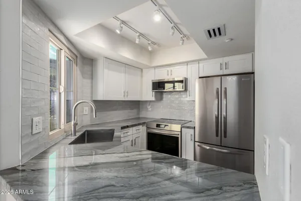 a kitchen with kitchen island a refrigerator sink and cabinets